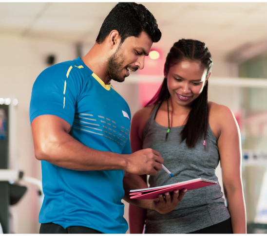 An image depicting a personal trainer engaging with a client, potentially during a workout session, can effectively convey professionalism and the supportive nature of the program. The image should showcase an inclusive environment, highlighting the trainer's guidance and the client's positive response to the training.