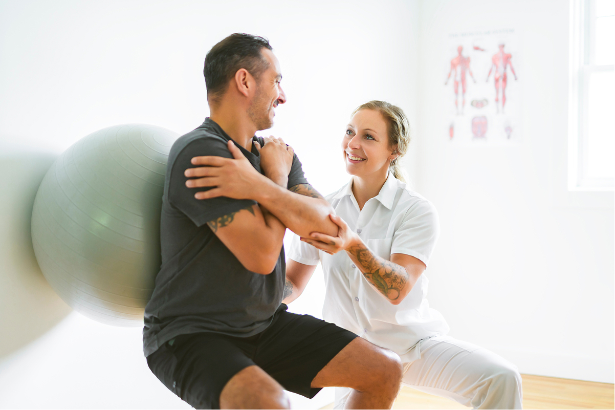 Female trainer assisting male client.